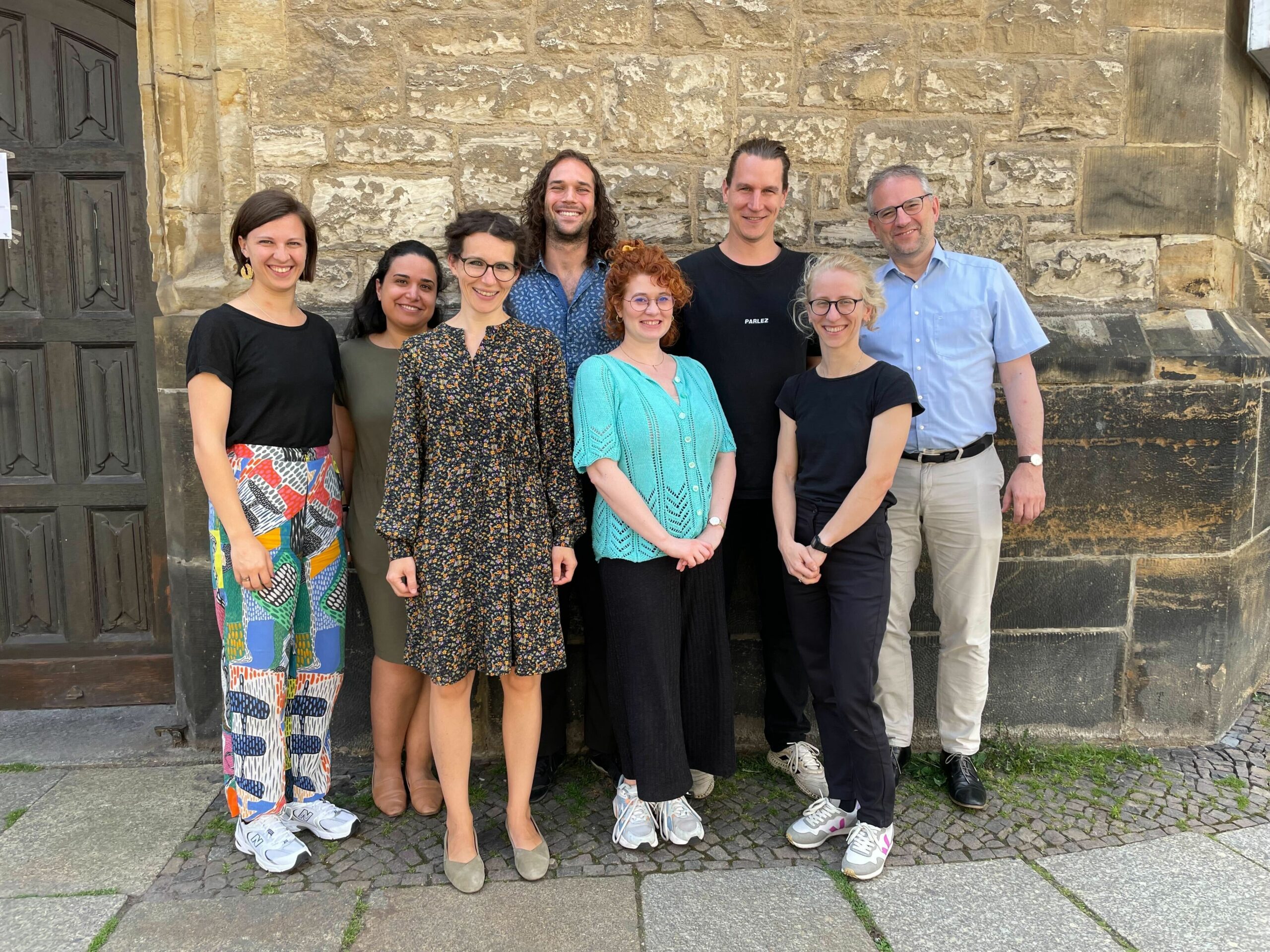 Group Picture of the ANCIP Team in front of the Nicolaikirche in Leipzig on a sunny day.