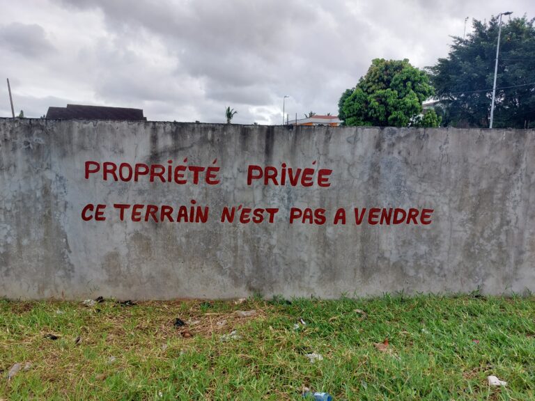 picture of a concrete wall with the text "propriété privee - ce terrain n'est pas a vendre" written on it in red lettering