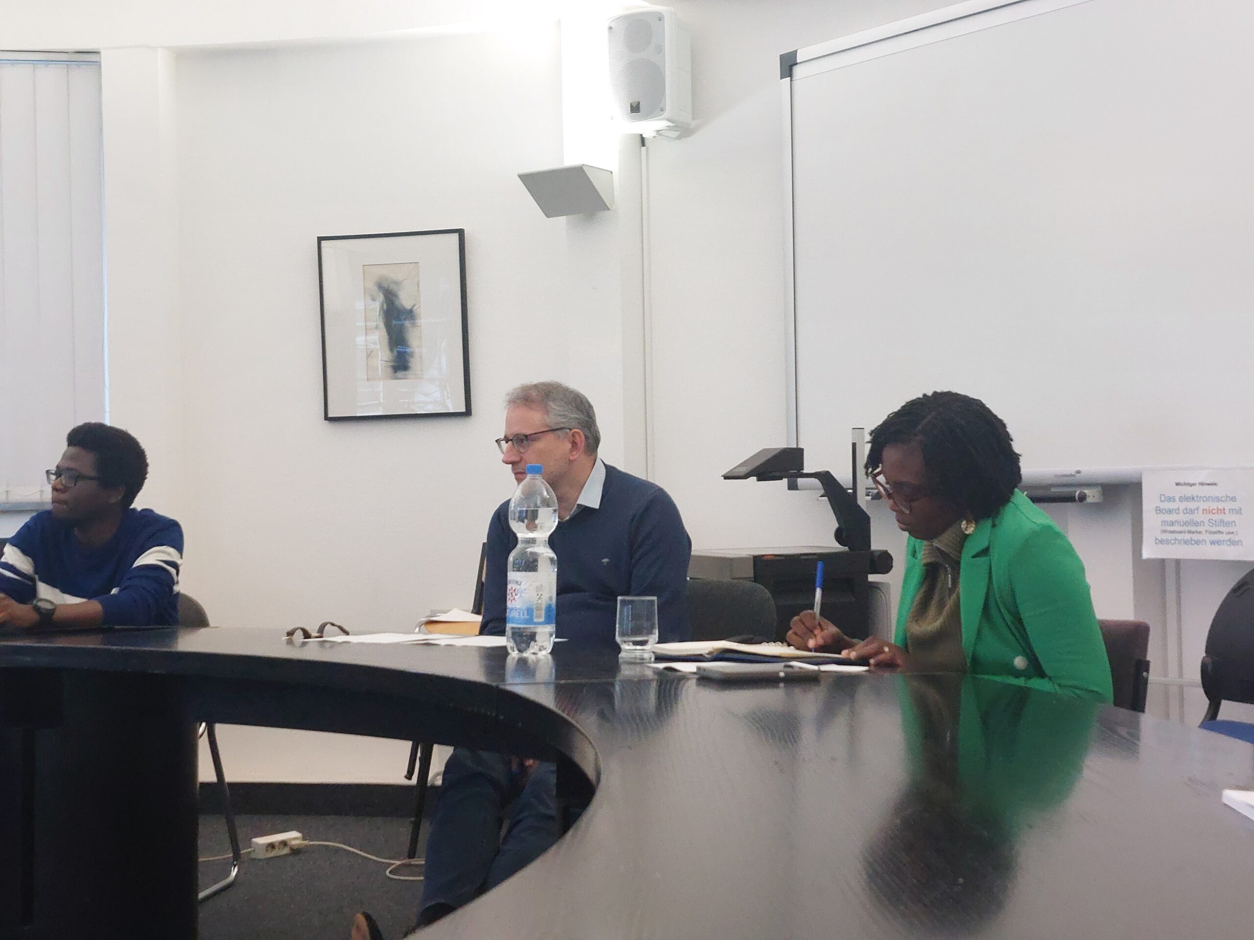 The picture shows three people sitting at a table.