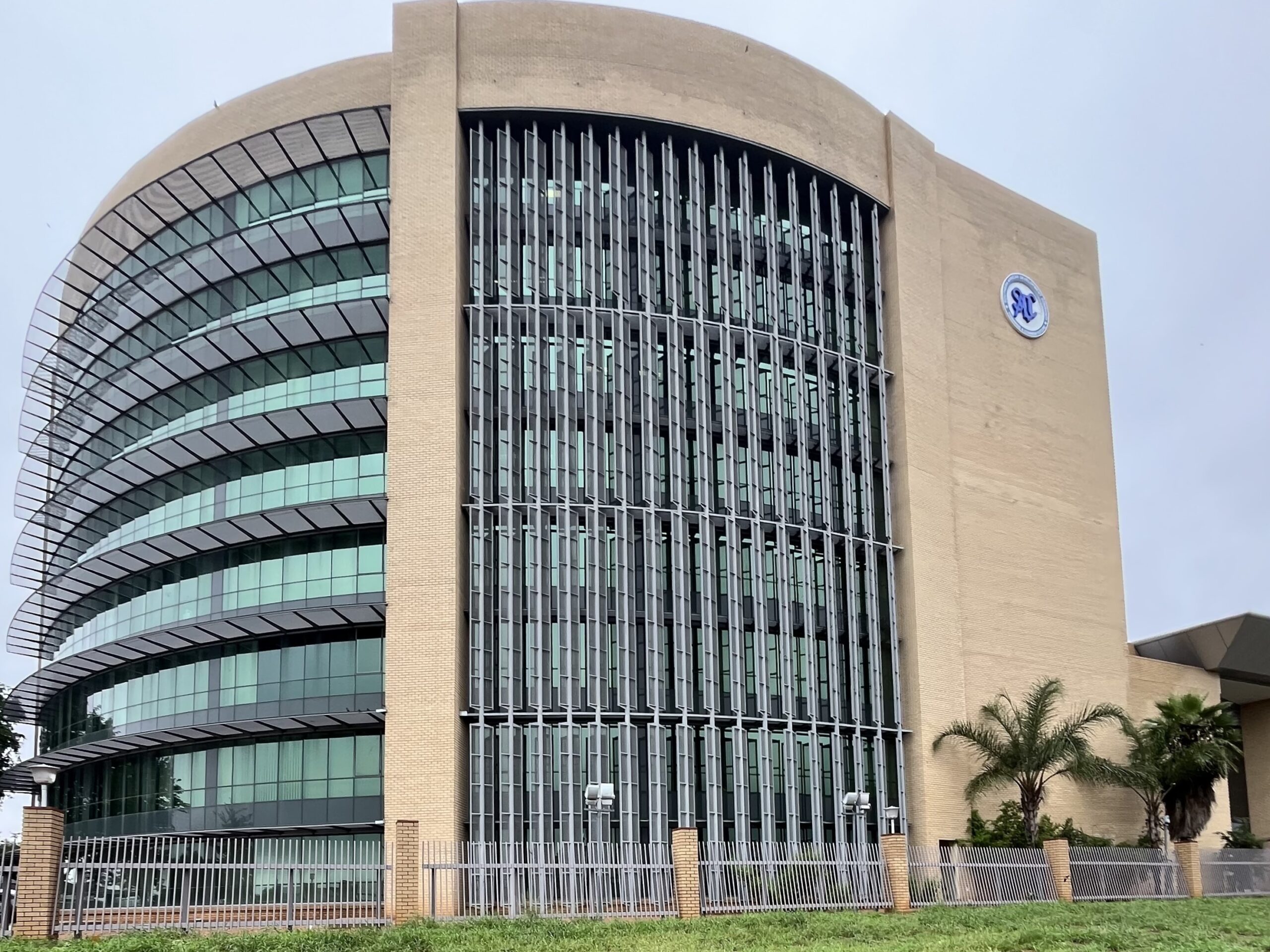 The picture depicts the SADC Headquarters. Large building from sanstone with big windows and the SADC logo on its right side.
